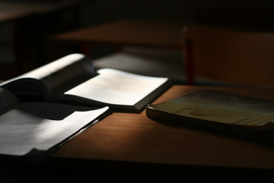 كتب مفتوحة على طاولة يمر فوقها ضوء دافئ