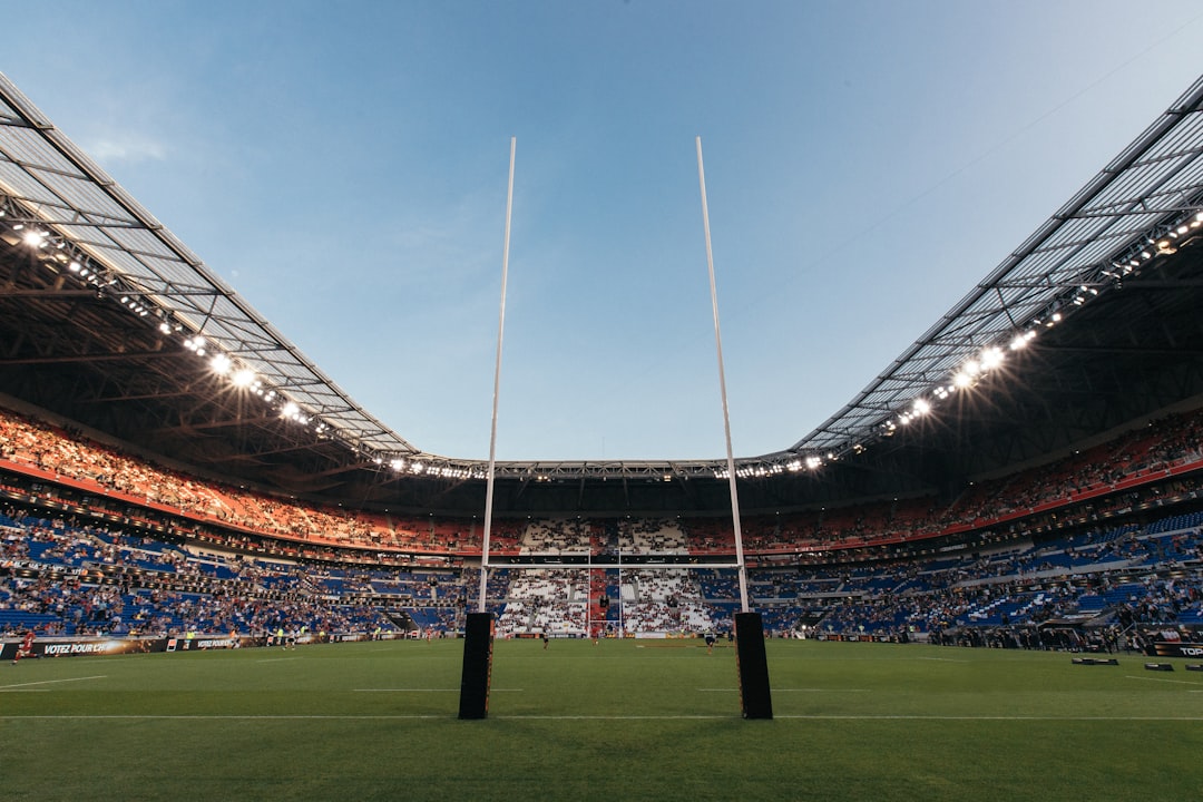 ملعب رغبي خالٍ ومدرجات تحيط بأرضية خضراء