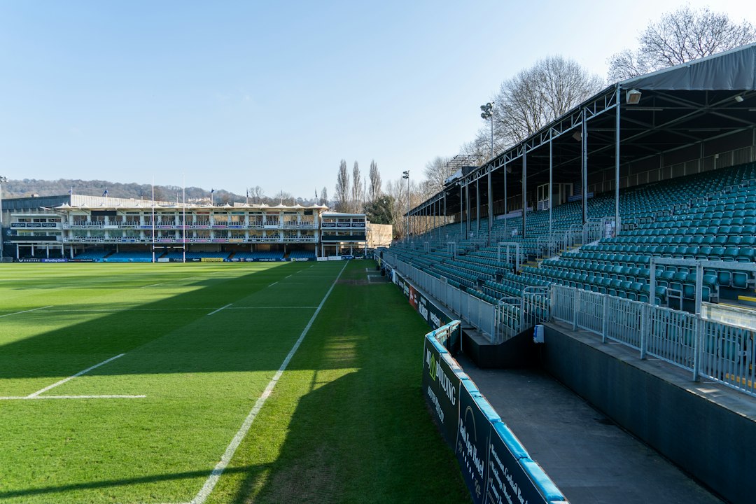 Leere Stadionränge neben einem grünen Spielfeld