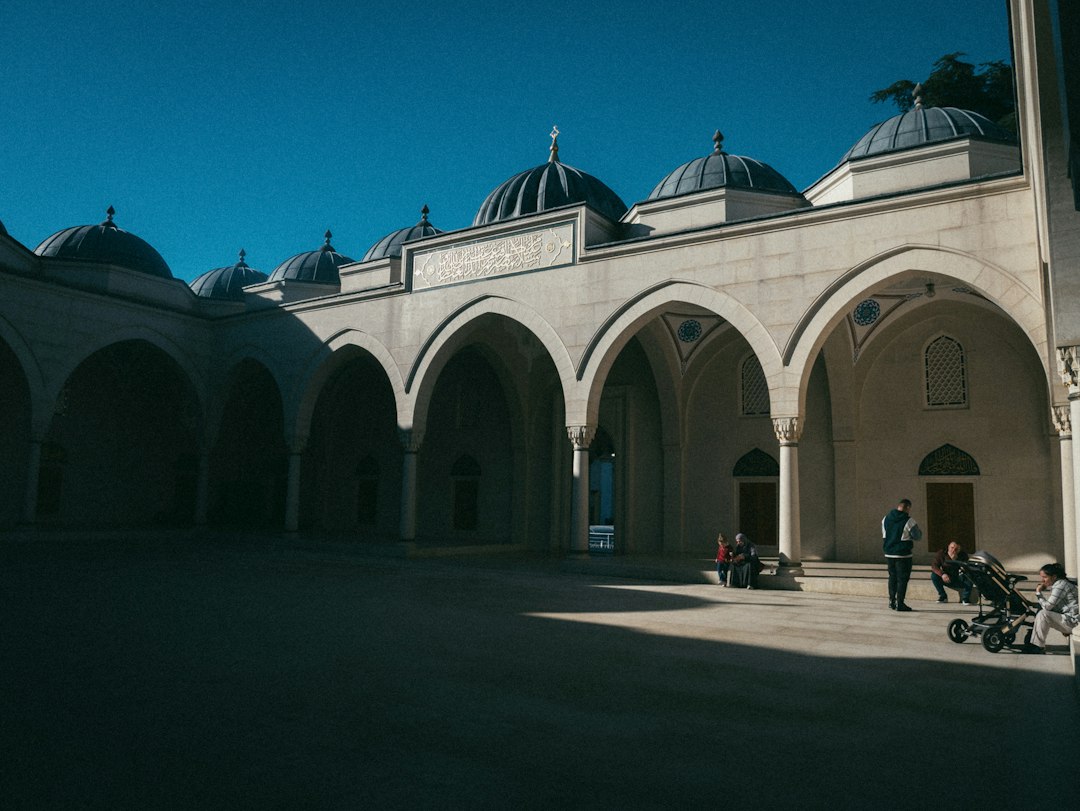ساحة مسجد ذات أقواس وقباب في ضوء النهار
