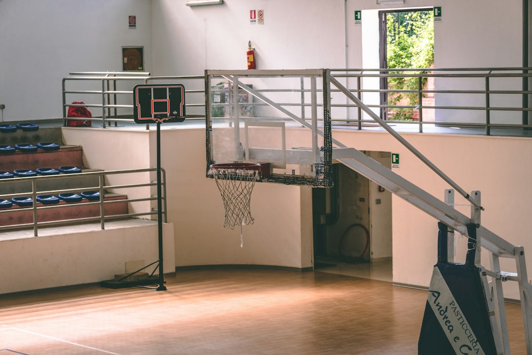 Ein leerer, von oben beleuchteter Basketballplatz in einer Halle