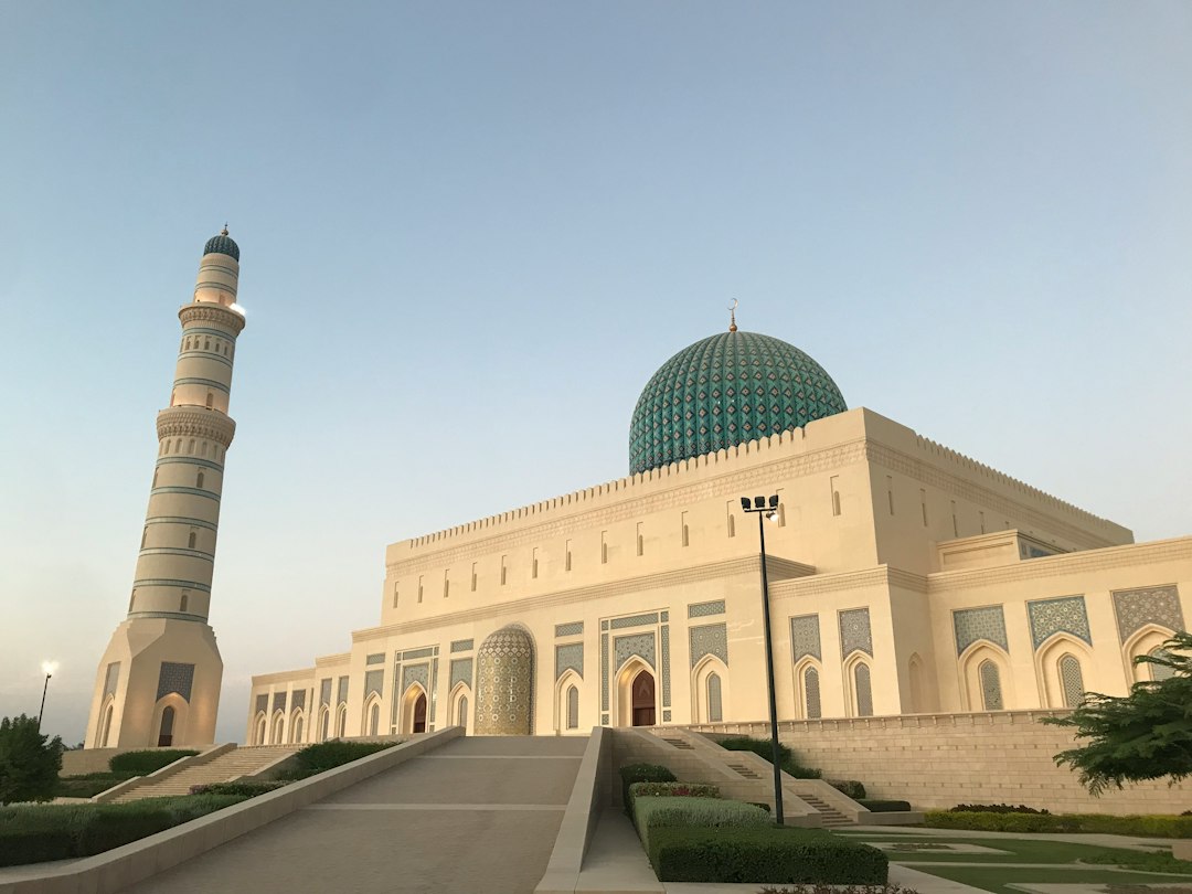 The entrance of a white mosque among trees